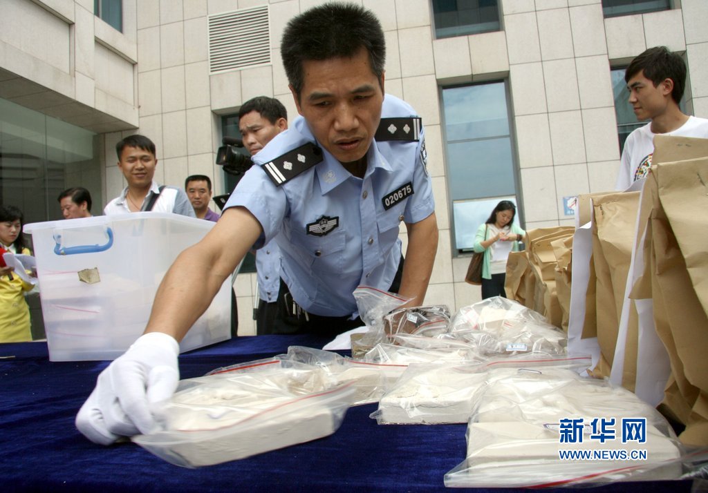 衡阳特警在特大贩毒现场缴获的毒品和毒资展示台前护卫.图片:cfp