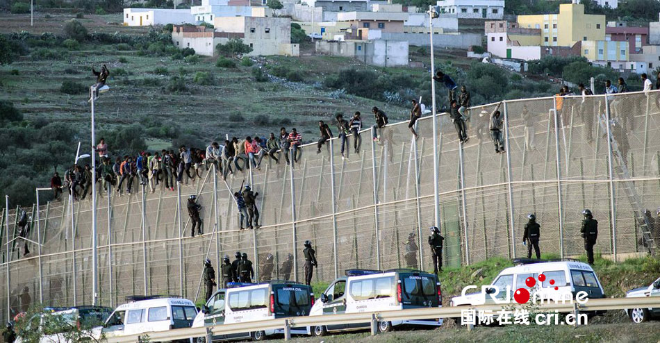 约300名非法移民欲翻越边境墙进入西班牙(高清