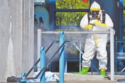 10月18日，在美国达拉斯的一个车站，一名身着隔离服的工作人员正在喷洒消毒药水。当日，一名女性在达拉斯的一个车站病倒，病情症状疑似感染埃博拉病毒。新华社发