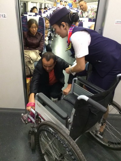 刘莉悉心帮助一位无法正常站立的旅客。
