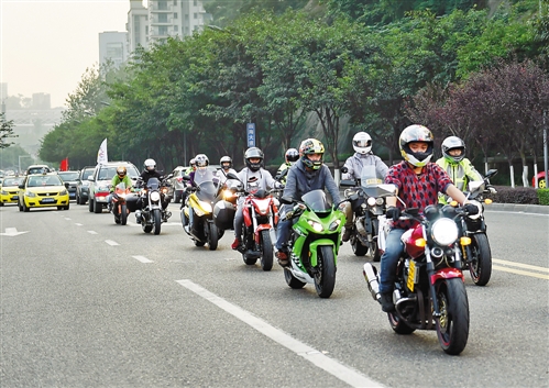 哈雷摩托车队伍,护送中国-东盟国际汽车拉力赛车队行驶在市区的公路上
