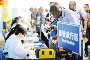 10月24日，在广州白云国际机场入境专用查验通道，出入境检验检疫局工作人员对来自几内亚、塞拉利昂、利比里亚、刚果金及尼日利亚的旅客进行健康登记和发放健康医护包。