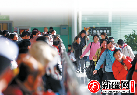 11月1日16时07分，在乌鲁木齐火车南站4号候车厅，乘坐L208次列车的棉农工准备进站。（本报记者陈星宇摄）
