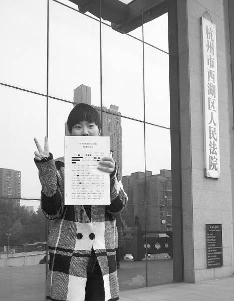 左手举着判决书,右手比着“V”,黄蓉(化名)在浙江省杭州市西湖区人民法院门口,拍下了拿到判决书的这一刻。黄蓉供图