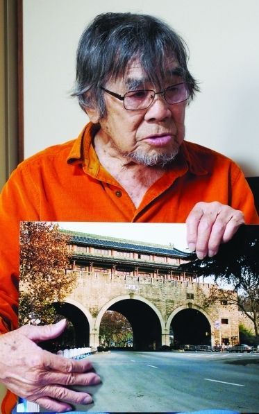 2007年12月，南京大屠杀发生70周年之际，三谷翔重返南京，在挹江门前留影，并向南京人民道歉。图为他向记者展示照片。 新华报业全媒体记者 余萍
