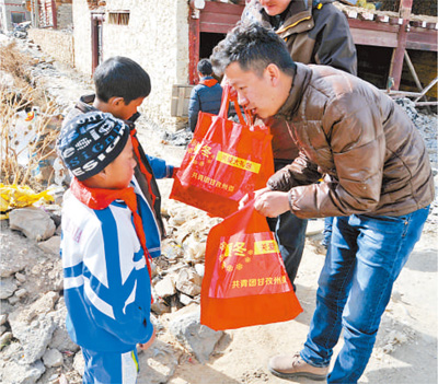2013年，袁雅逊（右一）参加甘孜州“心愿快车”之暖冬圆梦活动，与藏族小朋友在一起。