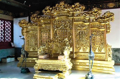昨天,嵩祝名院地点的嵩祝寺及智珠寺内,一处被用作餐馆的古修筑内摆放着一张“龙椅”,这张“龙椅”是依照故宫里的龙椅等份额制造的(视频截图)。新华社记者 李德欣 摄
