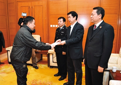 王国强（左）在首都机场向纪检监察机关递交自首书。