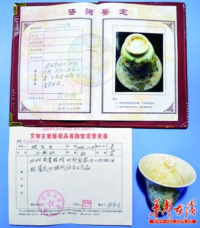 记者花90元买到的瓷杯与"文物鉴定书". 记者 李健 摄