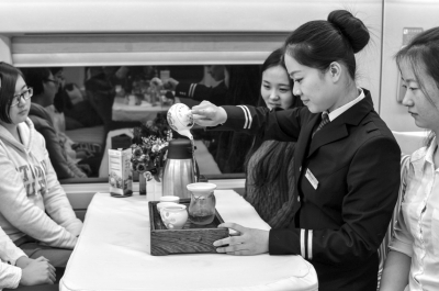 茶艺师在餐车内为游客沏茶。