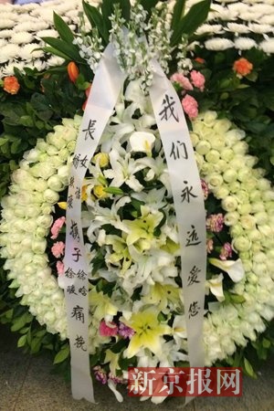 李小文的妻子,女儿等家属的花圈摆在遗像正下方,挽联上写着"我们永远