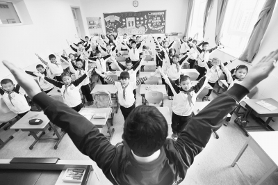 由于雾霾天气,一些中小学学校的体育课改在了教室进行。