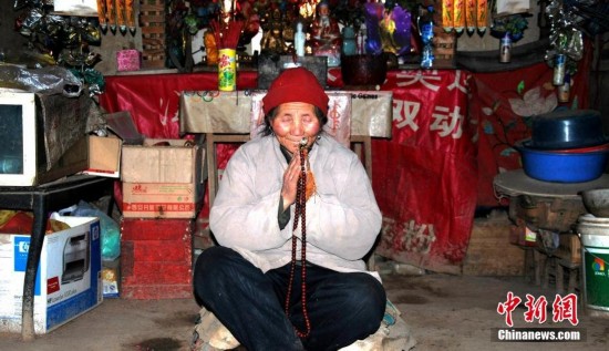 83岁的王芝霞是众多修行隐士之一，出生于1932年农历八月初六，于终南山修行36年。性情开朗，常笑称自己为终南山上的“疯老太婆”。图为静心打坐。李思默 摄