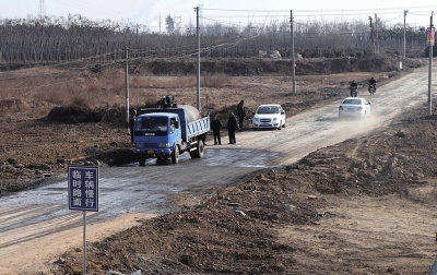 2月5日，车辆在平整后的临时路面上行驶，被毁公路水泥路面的碎块已被清理。新华社发