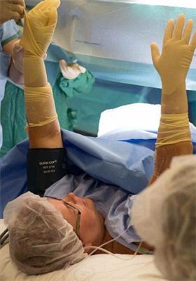 手术前沃尔夫做足准备,带上护士取出婴儿时的橡胶手套.