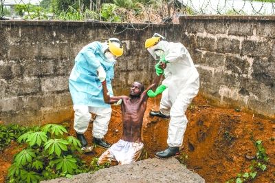 治疗中心拍摄的医护人员将因埃博拉病毒导致癫狂的患者带回隔离病房