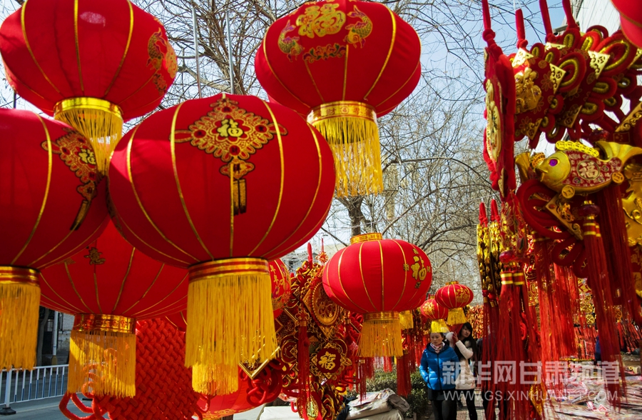 2月13日,甘肃永靖市民在市场上选购象征吉祥寓意的红灯笼,中国结,年画