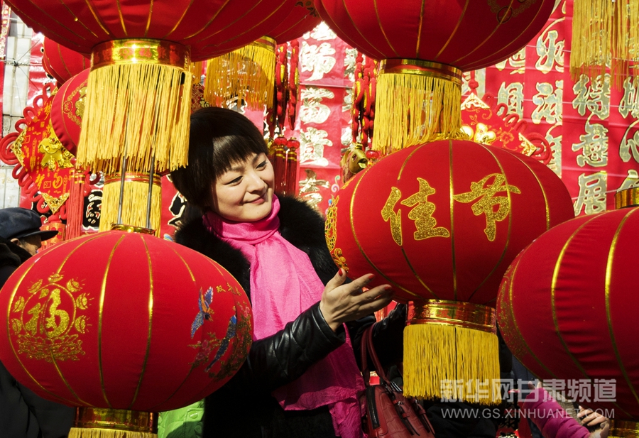 2月13日,甘肃永靖市民在市场上选购象征吉祥寓意的红灯笼,中国结,年画