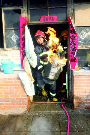 北京晨报讯(记者 岳亦雷)北京消防再现“抱火哥”!前天上午,怀柔区北房镇郑家庄一户居民家中厨房起火,雁栖消防中队抵达现场,发现有煤气罐正在燃烧,中队长范文超果断将燃烧的煤气罐抱到屋外空旷处(如图),避免了火情扩大。