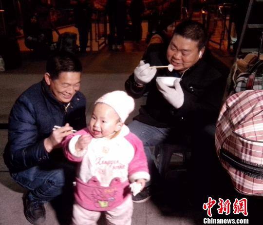 重庆火车站春运返程旅客获赠爱心餐，吃上热气腾腾充满年味的汤圆。 罗敏 摄