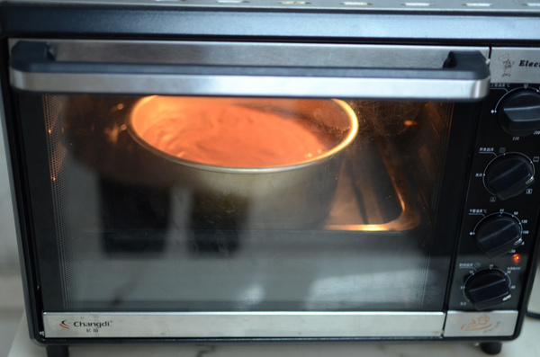 把拌好的面糊倒入模具里,放入预热好的烤箱烘烤,上火150度,下火120