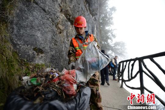 “蜘蛛侠”清扫悬崖树枝上的垃圾。 邵颖 摄