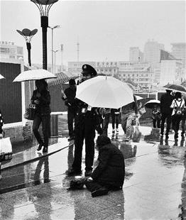 楚天都市报讯 楚天都市报讯（记者叶文波 王永胜）昨日，在光谷步行街，保安撑着一把伞，为一个坐在地上的乞讨婆婆遮雨，被网友赞为“中国好保安”。