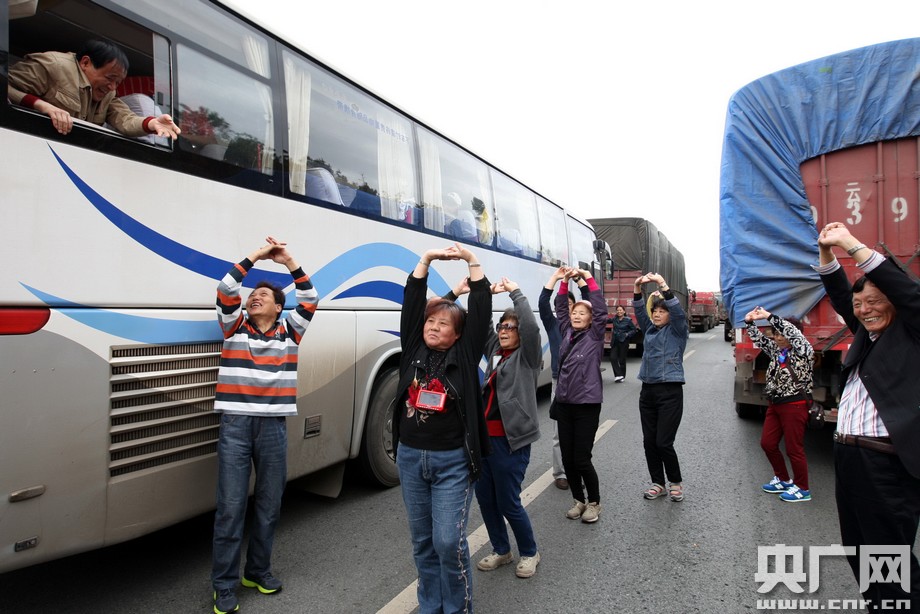 被堵路上的大妈在车缝中跳起广场舞,更有大叔大妈直接对舞起来,场面犹如“斗舞”,十分火爆。