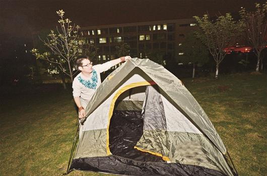 图为:昨晚,找不到旅店的张才溢在武汉理工大校园内支起帐篷过夜 楚天