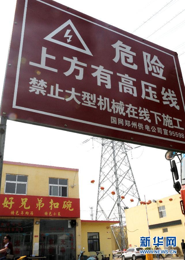这是郑州市惠济区薛岗村水产市场内的高压线警示牌(4月28日摄.