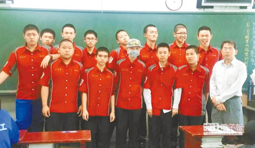 萧钰隆(前中戴帽者)因化疗而掉秃顶发,班上10余个同窗在导师林晋禄(前右)的召唤下,陪着他一同理秃顶或剪平头。《国家时报》