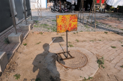 小湘�h溺亡后，涉事化粪池被盖上了井盖，上面还设置了警示牌。 新京报记者 王嘉宁 摄