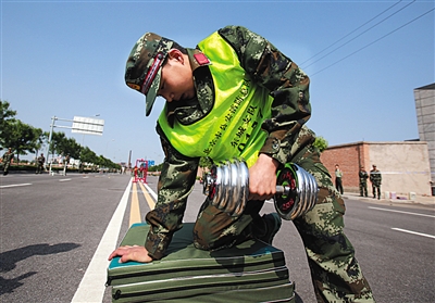 一名参赛消防官兵正在进行哑铃项目的比赛。