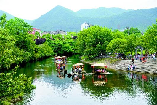 湖北讯 10日,一批游客在京山县绿林景区美人谷乘坐竹筏,赏景游玩.