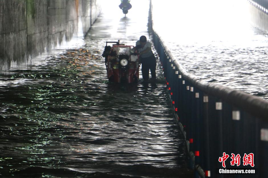 广西暴雨致部分道路内涝 市民淌水而行(组图)
