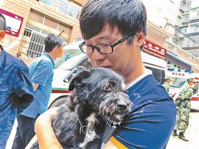 5月21日，25岁的周嘉俊在事故现场抱着自己半岁多的小狗“丑妹”，泣不成声。小狗事故时被压在废墟之下，于当日13时许被救出。