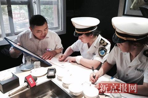 北京市卫生监督局的执法人员执法人员开出了禁烟《责令整改通知书》。新京报记者 吴江 摄