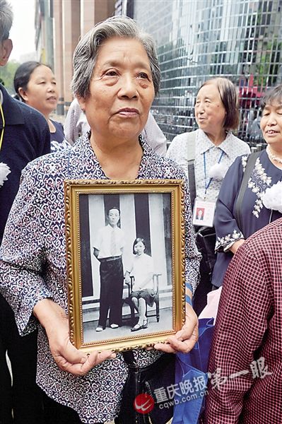 大轰炸幸存者带着遇难父母的遗像前来参加纪念活动