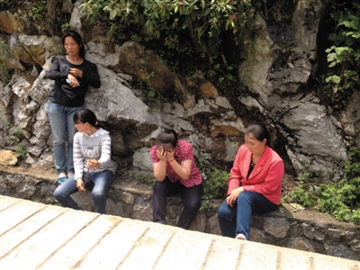 四兄妹的家属，在事发的房子前痛哭，右边两位是四兄妹的亲姑姑。新京报记者 范春旭 摄