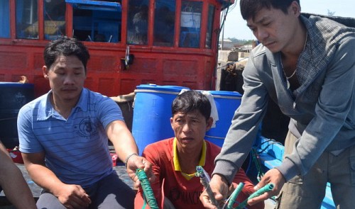 几名越南渔民在展示被中方破坏的捕鱼设备