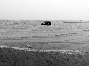 男子开豪车去看海 不料涨潮陷在沙滩上