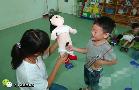 一个女孩在老师的引导下从"妈妈"肚子里"接生"出小宝宝.