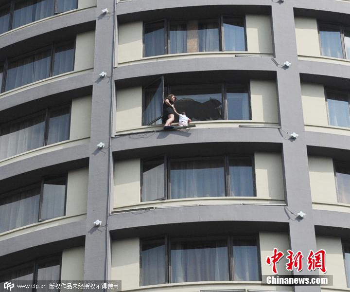 6月29日，广西桂林市市区一女子带着2岁的女儿爬到一酒店的13层楼的窗户外，准备跳楼。在谈判过程中，救援人员得知女子是因为与丈夫闹矛盾才欲跳楼。为了让女子放心，救援人员找来民政局工作人员，现场协助女子与其丈夫签署离婚协议书后，女子这才带着女儿爬进房间。铭鑫片来源：CFP视觉中国