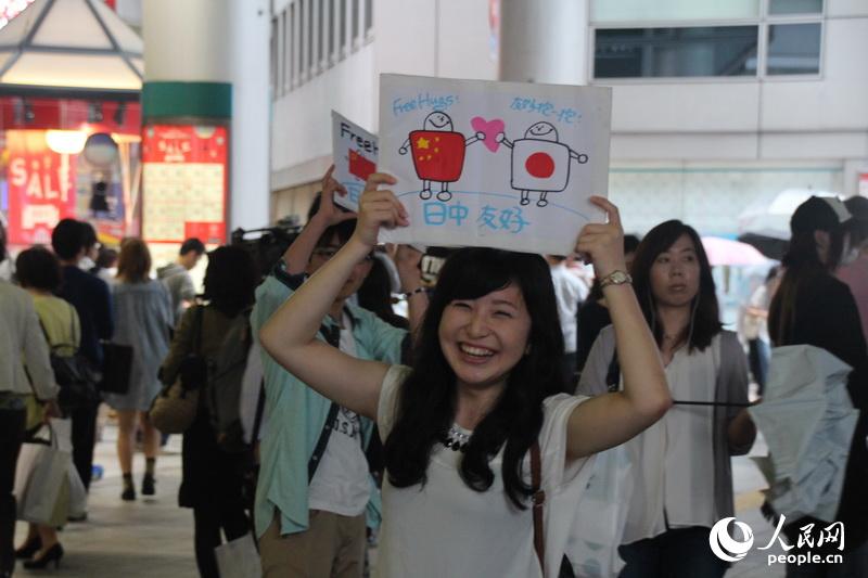 中日年轻人在东京街头开展"中日友好抱一抱"活动(组图