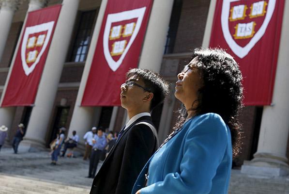 2015年5月8日，一名学生和家人参加哈佛大学毕业典礼。CFP 资料