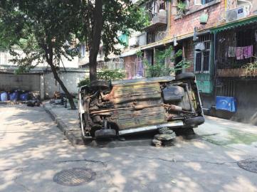 僵尸车被居民推翻后停在小区楼道口。