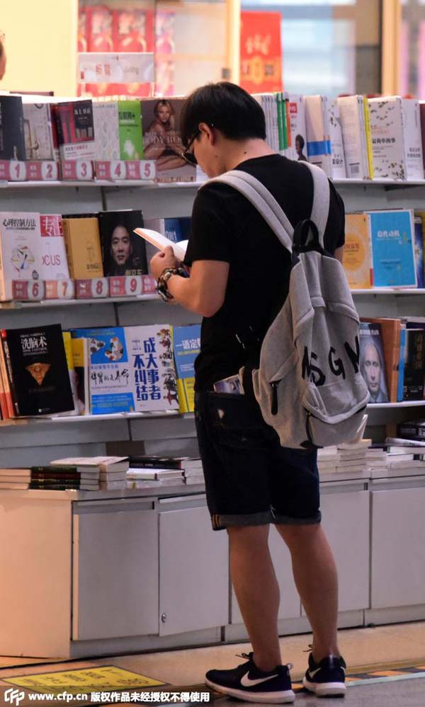 黄渤机场候机钻书店看书 背双肩包穿着休闲专
