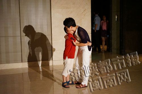 薛女士抱着儿子,向他解释为何要坚持让那位女士道歉