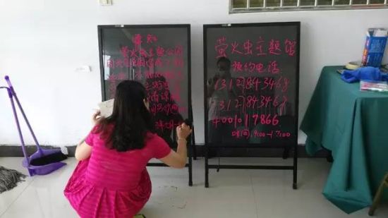 王玲用品红色的荧光笔在玻璃黑板上写活动不能如期举行的通知―“因天气原因造成工期延误”。