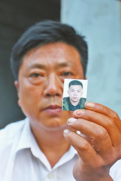 董应双手持儿子董正辉的相片